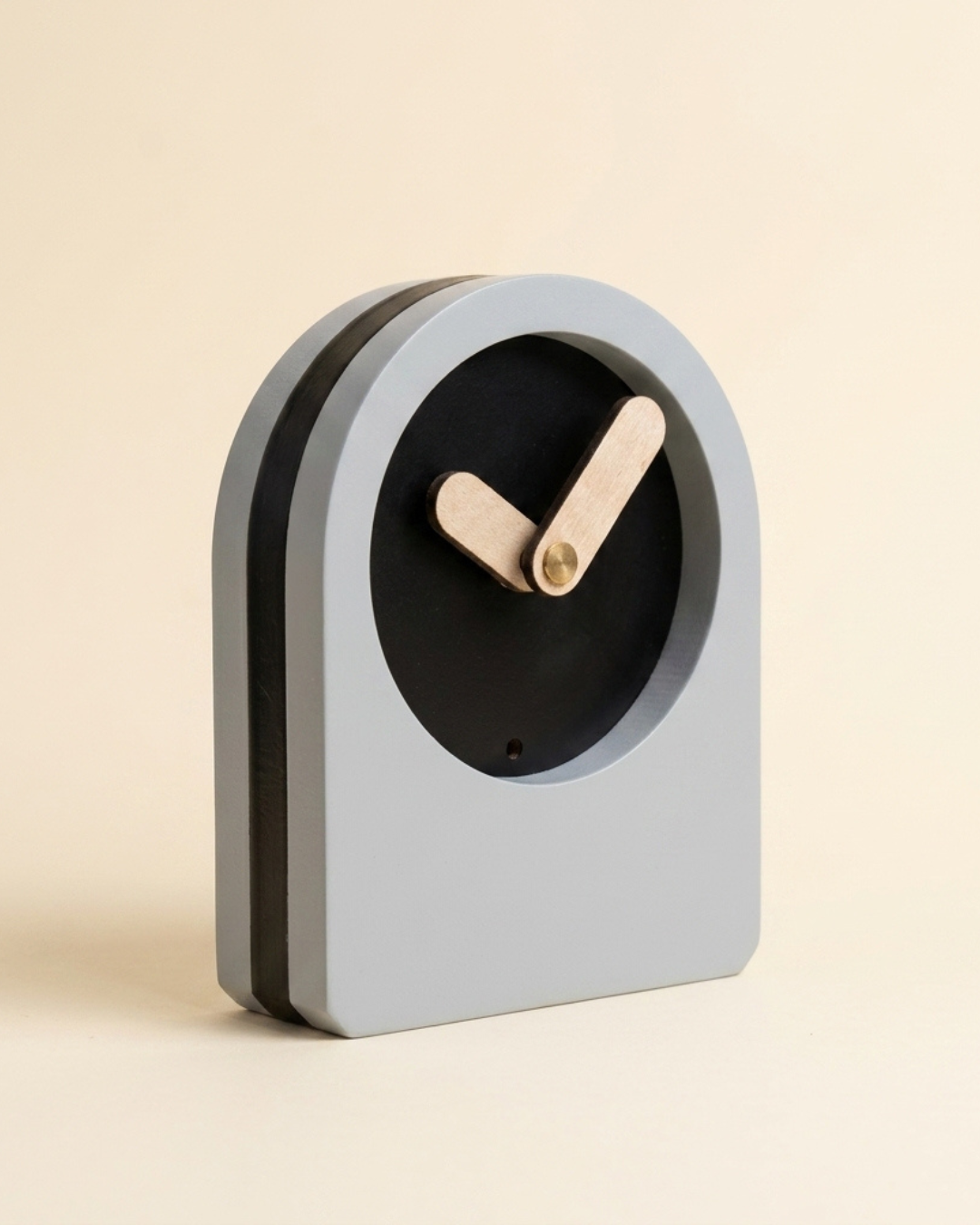Gray clock with wooden hands on a beige background